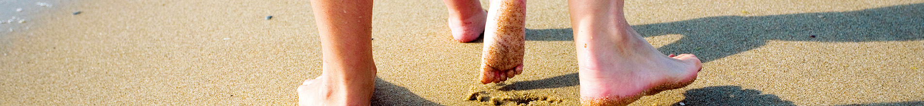 Feet leaving behind footprints in the sand